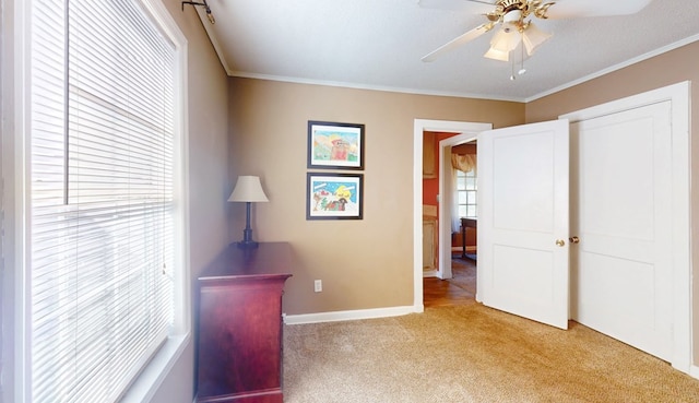 bedroom with ornamental molding, light colored carpet, and ceiling fan