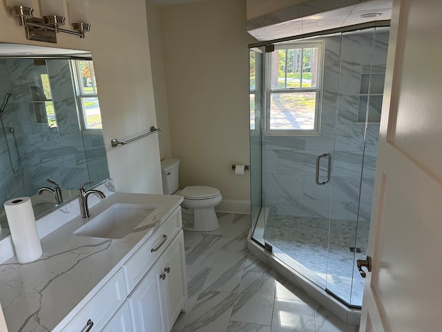 bathroom with a shower with door, vanity, and toilet