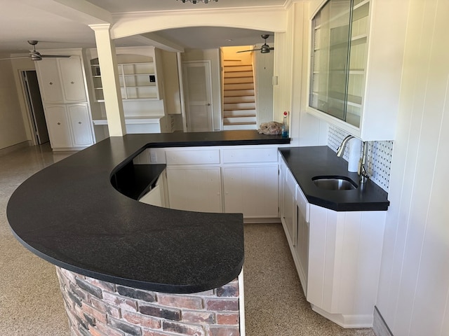 kitchen with white cabinetry, sink, and ceiling fan