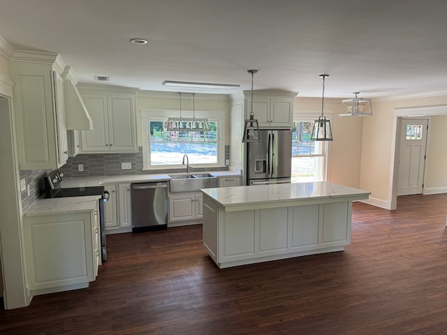 kitchen with pendant lighting, sink, stainless steel appliances, light stone counters, and a kitchen island