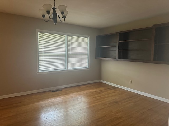 unfurnished dining area featuring a chandelier and hardwood / wood-style floors