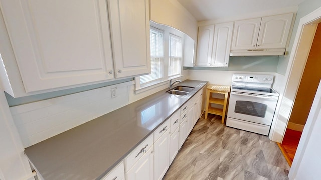 kitchen featuring white electric stove, a sink, white cabinets, and under cabinet range hood