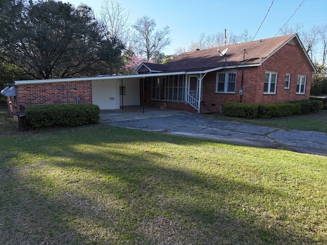 view of front of house featuring aphalt driveway, brick siding, crawl space, an attached carport, and a front lawn