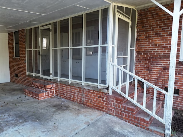 view of exterior entry featuring brick siding