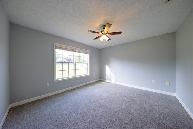 carpeted empty room with a textured ceiling, baseboards, and a ceiling fan