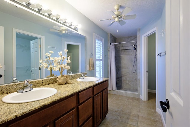 full bath with a ceiling fan, double vanity, a sink, and a stall shower