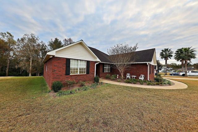 ranch-style home with a front yard and brick siding
