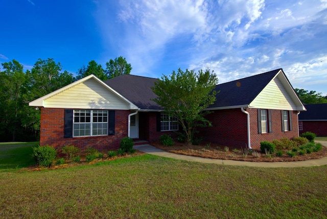 single story home featuring brick siding and a front yard
