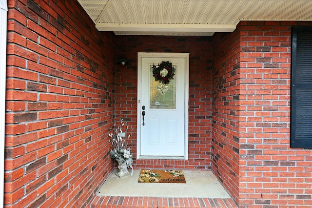 doorway to property with brick siding