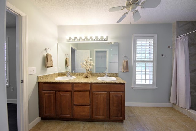 full bathroom with a wealth of natural light, a ceiling fan, and a sink