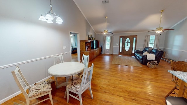 dining space featuring crown molding, high vaulted ceiling, light hardwood / wood-style floors, and a wealth of natural light