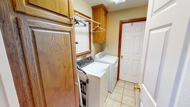 laundry area featuring cabinets, light tile patterned flooring, and washing machine and clothes dryer