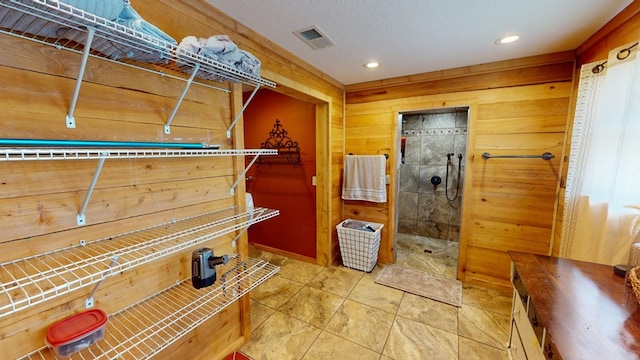 bathroom with walk in shower, wooden walls, and a textured ceiling