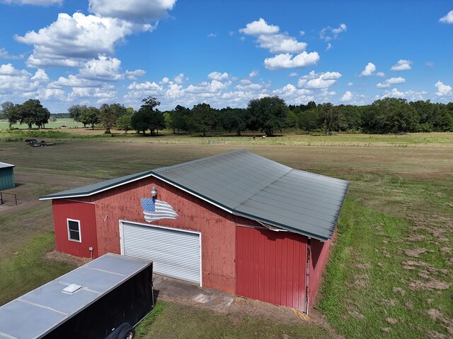 view of outbuilding with a yard and a rural view