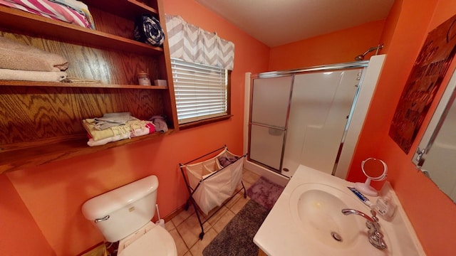 bathroom featuring sink, tile patterned floors, a shower with door, and toilet