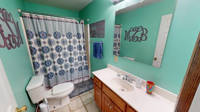 bathroom with vanity, toilet, curtained shower, and tile patterned flooring