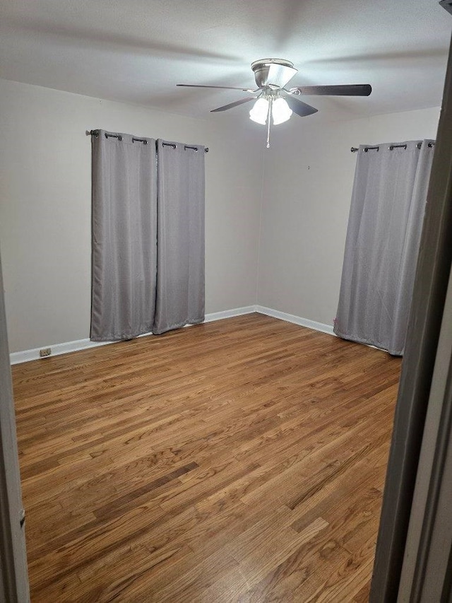 spare room with hardwood / wood-style floors and ceiling fan