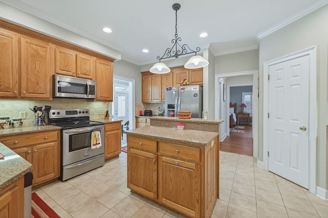 71 Buckfast Ct, Thomasville, GA 31792 - kitchen featuring appliances with stainless steel finishes, ornamental molding, backsplash, a kitchen island, and light tile patterned flooring