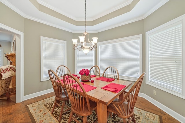 71 Buckfast Ct, Thomasville, GA 31792 - dining area with a chandelier, a raised ceiling, healthy amount of natural light, wood finished floors, and ornamental molding