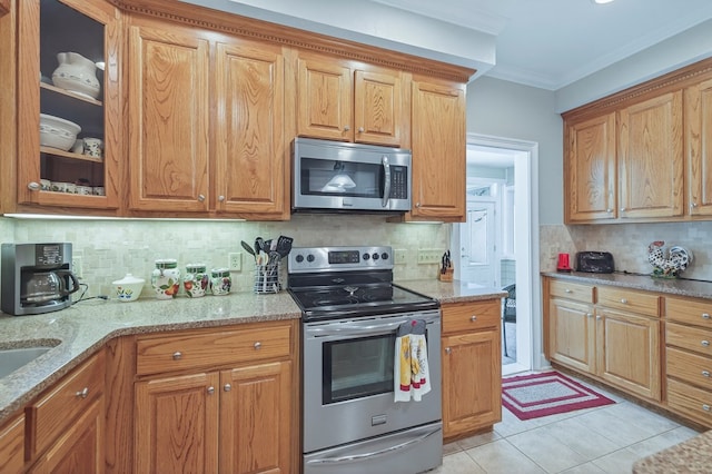 71 Buckfast Ct, Thomasville, GA 31792 - kitchen featuring stainless steel appliances, tasteful backsplash, crown molding, light stone countertops, and glass insert cabinets