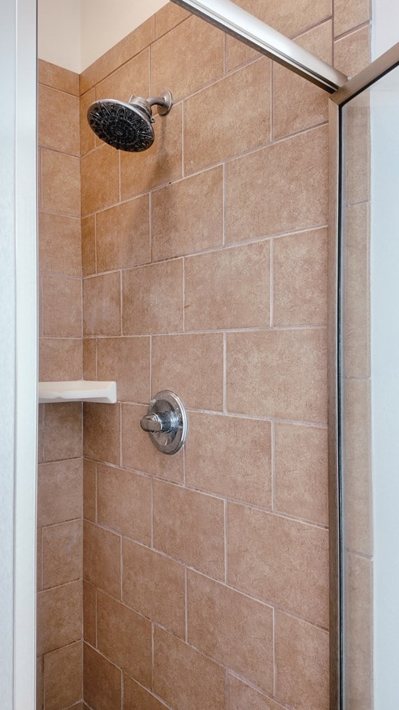 interior details featuring a tile shower