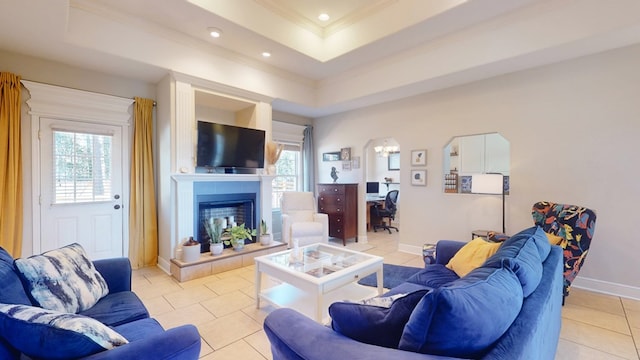 tiled living room featuring crown molding and a tray ceiling