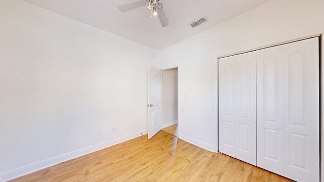 unfurnished bedroom with light hardwood / wood-style floors, a closet, and ceiling fan