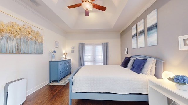 bedroom featuring ceiling fan, dark hardwood / wood-style flooring, and a raised ceiling