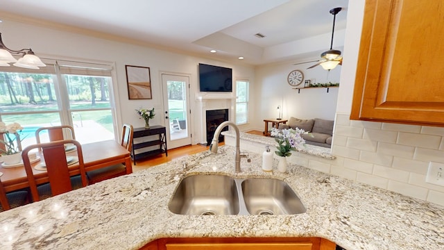 316 Bellingham Dr, Thomasville, GA 31792 - kitchen featuring light stone countertops, tasteful backsplash, a fireplace, wood finished floors, and open floor plan