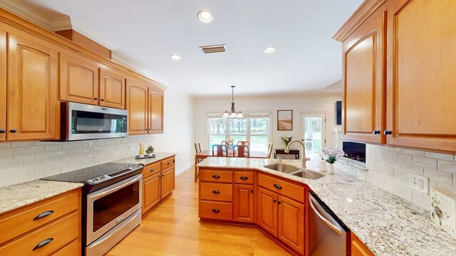 316 Bellingham Dr, Thomasville, GA 31792 - kitchen featuring appliances with stainless steel finishes, light wood-type flooring, light stone countertops, decorative backsplash, and recessed lighting