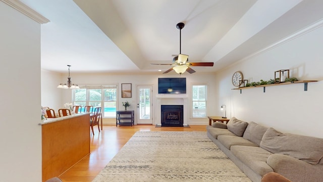 316 Bellingham Dr, Thomasville, GA 31792 - living room with light wood-style flooring, a tray ceiling, a fireplace with flush hearth, ceiling fan, and a chandelier