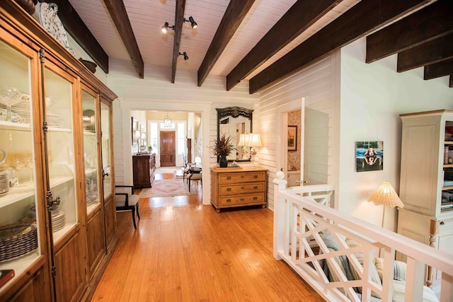 corridor with beam ceiling, rail lighting, wooden ceiling, and light wood-type flooring