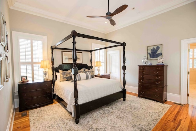 bedroom with ornamental molding, ceiling fan, and light hardwood / wood-style flooring