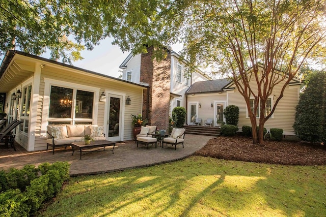 rear view of property featuring an outdoor living space, a yard, and a patio area