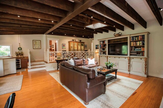 living room with beam ceiling and light hardwood / wood-style floors