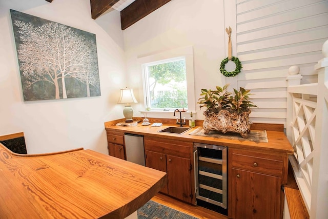 bar with butcher block countertops, sink, hardwood / wood-style floors, beverage cooler, and beamed ceiling