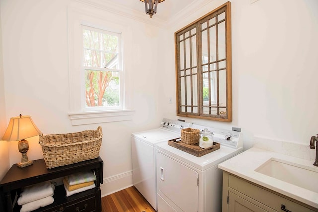 washroom with sink, crown molding, cabinets, separate washer and dryer, and light hardwood / wood-style flooring