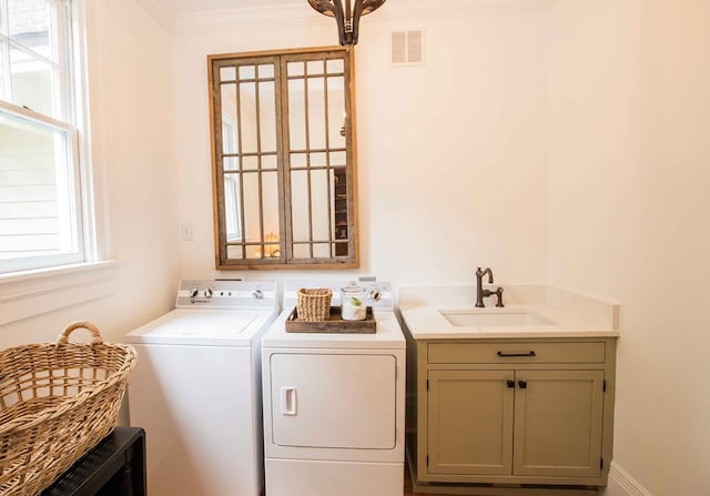 laundry room featuring cabinets, washing machine and dryer, and sink