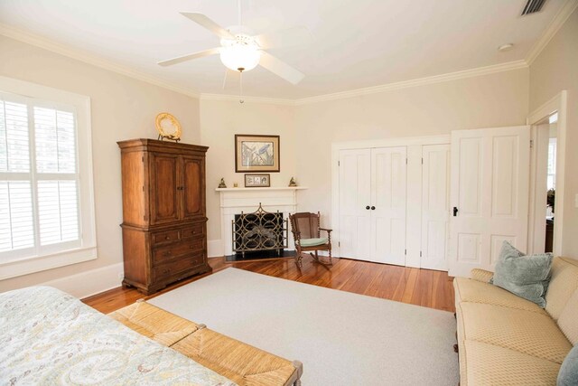 bedroom with ornamental molding, light hardwood / wood-style floors, a closet, and ceiling fan