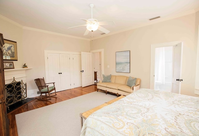 bedroom with crown molding, wood-type flooring, a closet, and ceiling fan