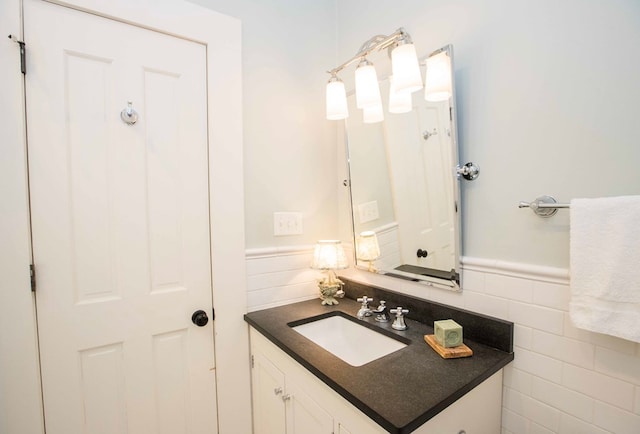 bathroom with vanity and tile walls