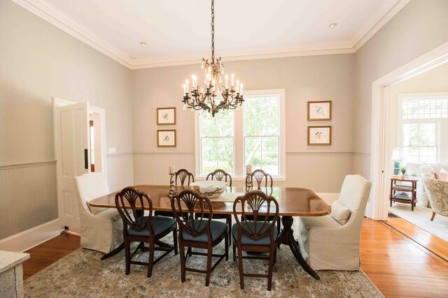 dining room featuring crown molding, hardwood / wood-style floors, and a chandelier