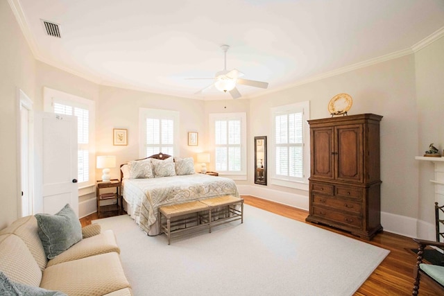 bedroom with ornamental molding, hardwood / wood-style floors, and ceiling fan