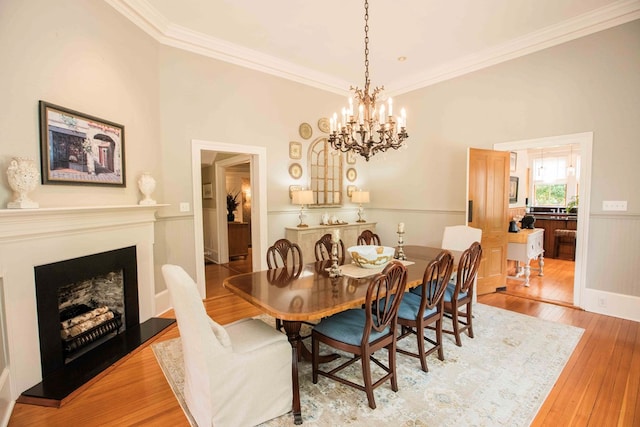 dining room with crown molding and light hardwood / wood-style flooring