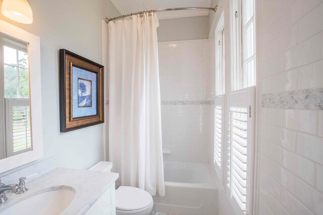 full bathroom featuring shower / tub combo with curtain, vanity, and toilet