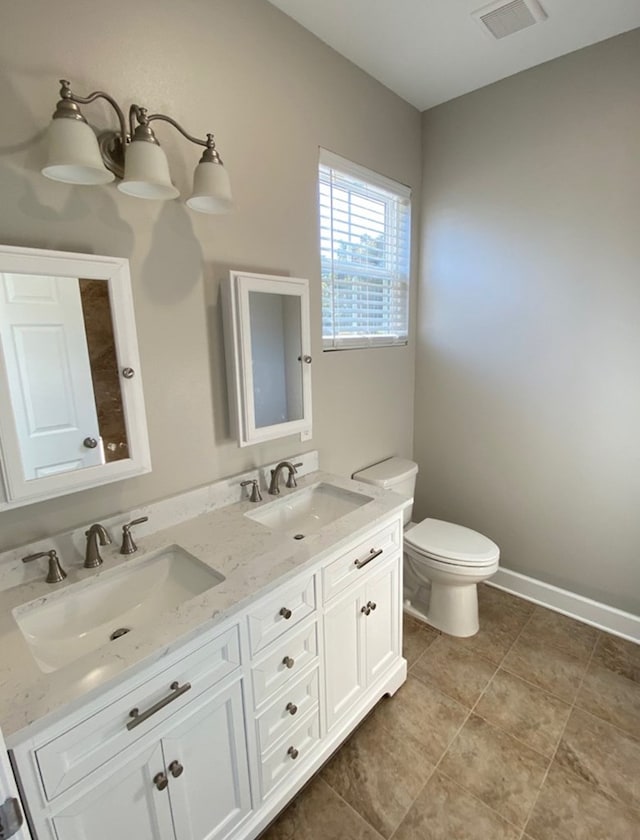 bathroom featuring vanity, tile patterned floors, and toilet