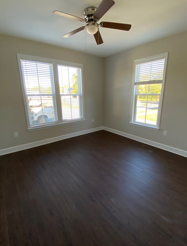 spare room featuring dark wood-type flooring and ceiling fan