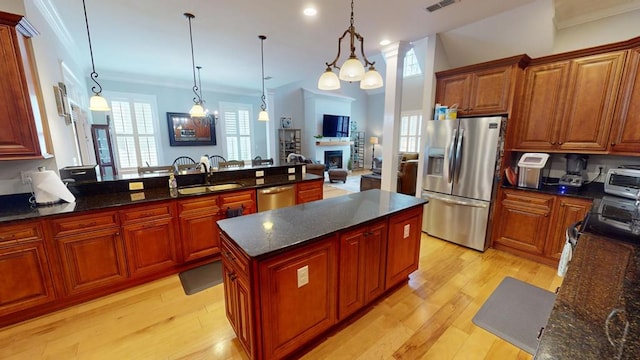 kitchen featuring pendant lighting, appliances with stainless steel finishes, sink, and dark stone counters