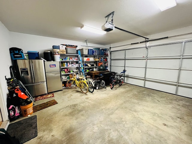 garage featuring a garage door opener, stainless steel fridge, and stainless steel fridge with ice dispenser