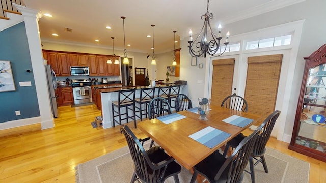 dining space with crown molding, a chandelier, and light hardwood / wood-style flooring